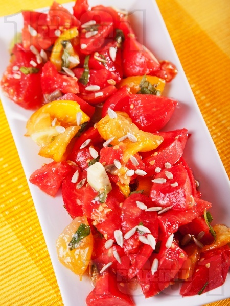 Салата с жълти и червени домати, авокадо и слънчогледови семки - снимка на рецептата